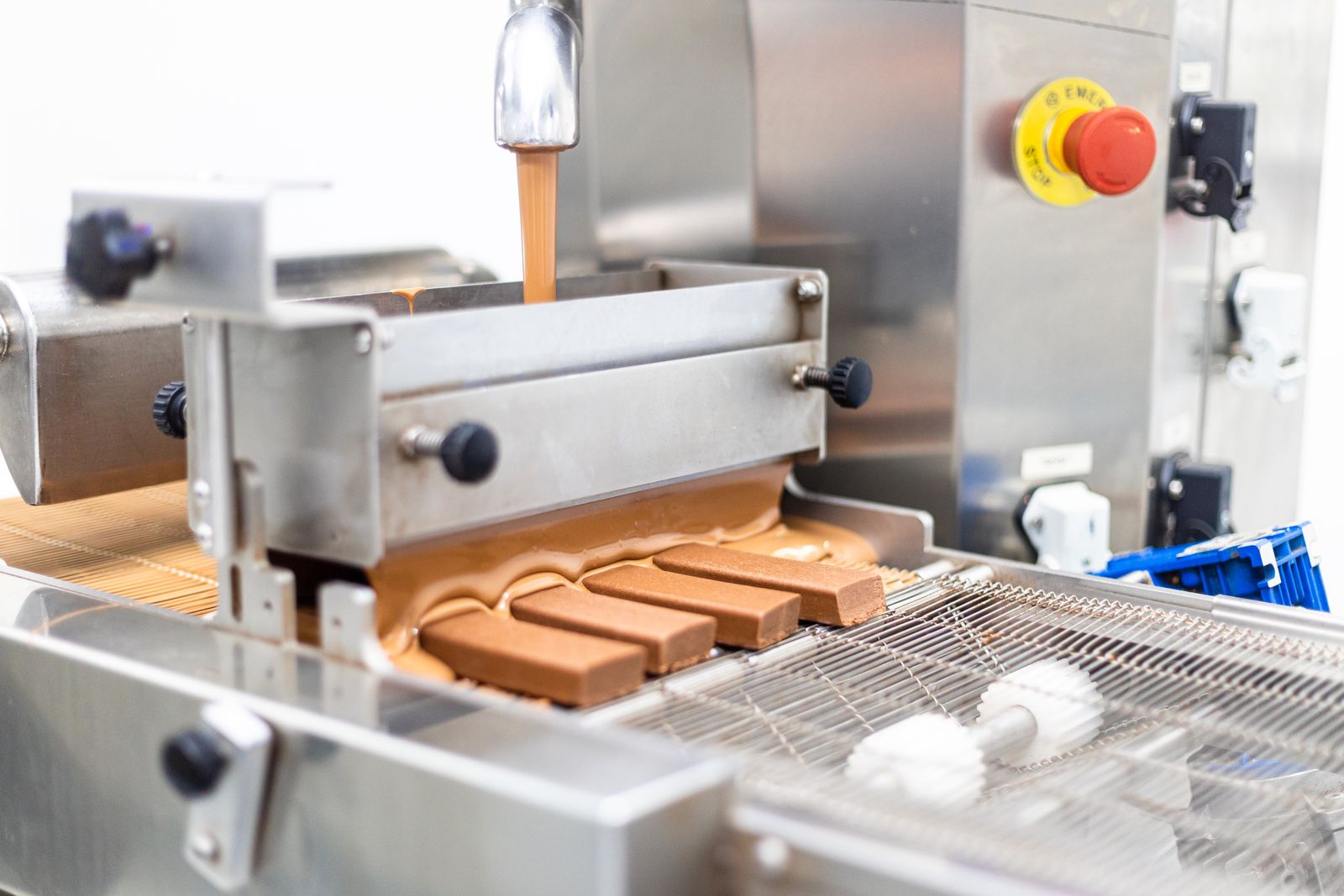 Bars passing through the chocolate curtain on the enrobing line